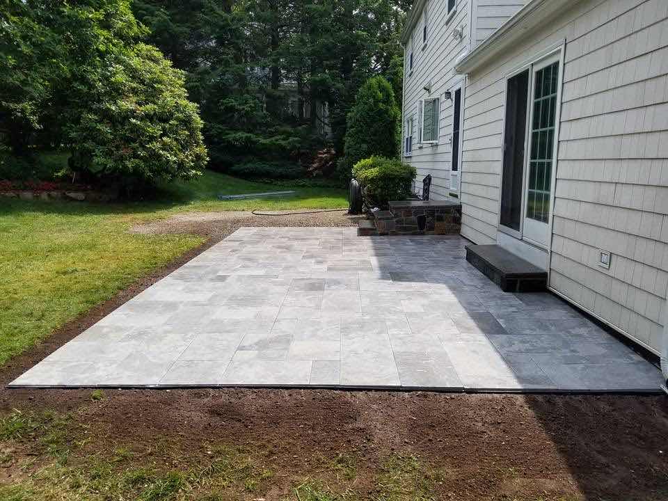 Bluestone patio with granite entry steps in a backyard, installed by Magic Tools Contracting