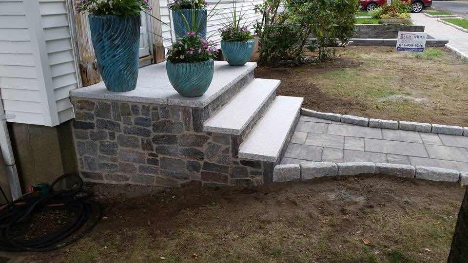Fieldstone and granite front porch steps with a curved granite walkway, built by Magic Tools Contracting