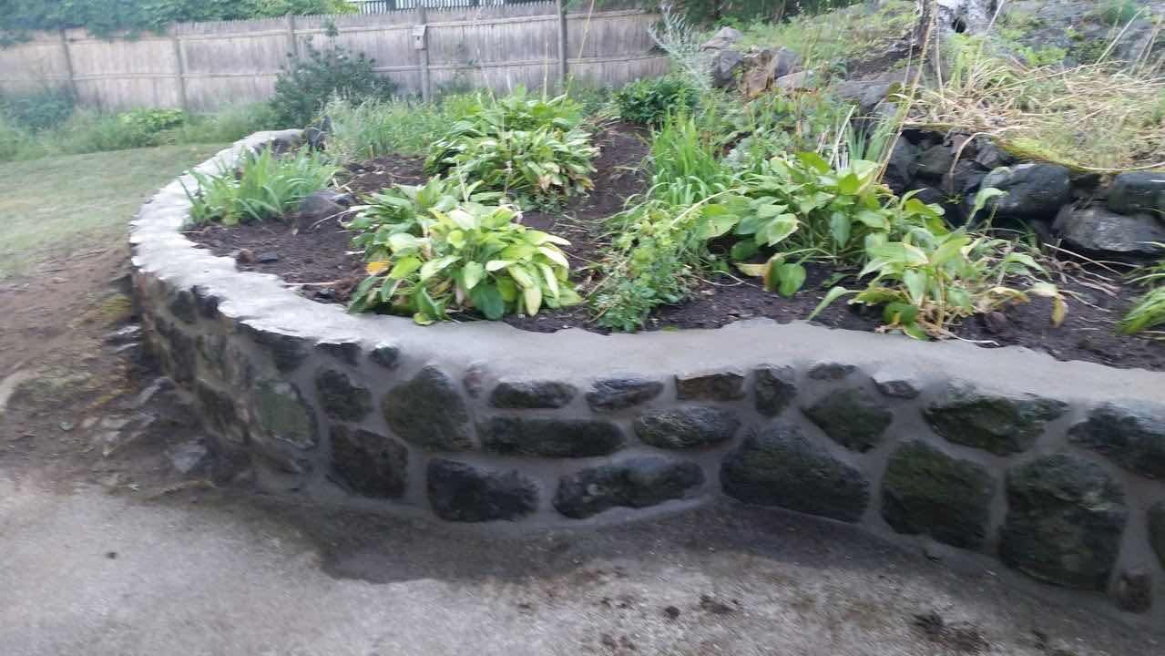 Close-up of a fieldstone retaining wall with mortar joints, built by Magic Tools Contracting