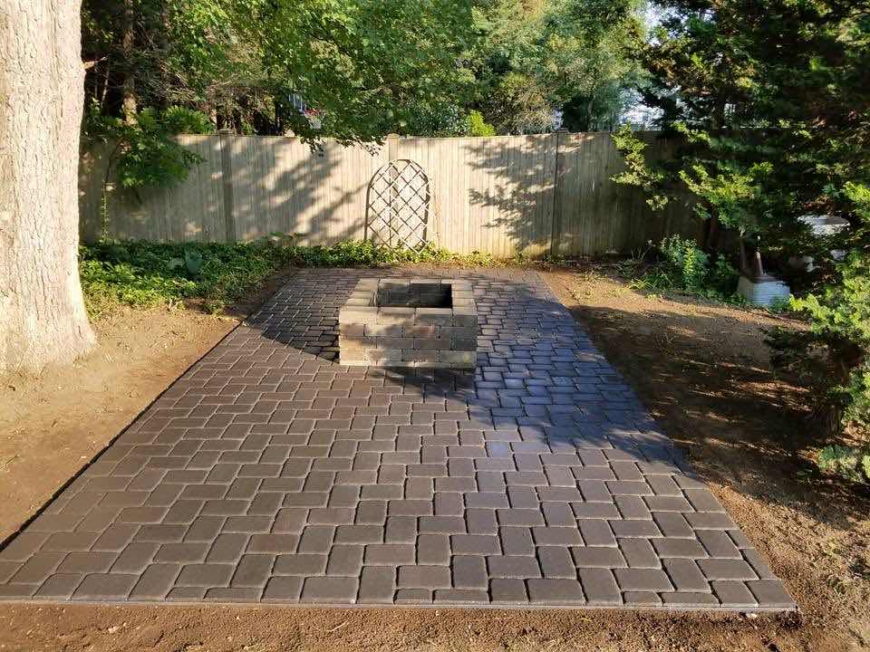 Backyard paver patio with a built-in block fire pit, installed by Magic Tools Contracting