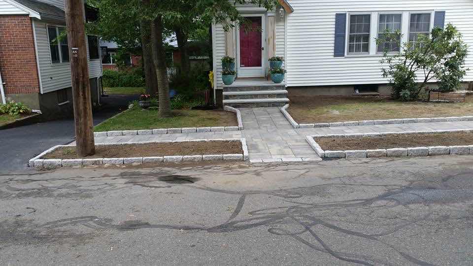 Paver walkway with granite curbing leading to a front porch, installed by Magic Tools Contracting